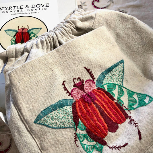 Example of completed scarab  beetle embroidery on cotton canvas project bag .