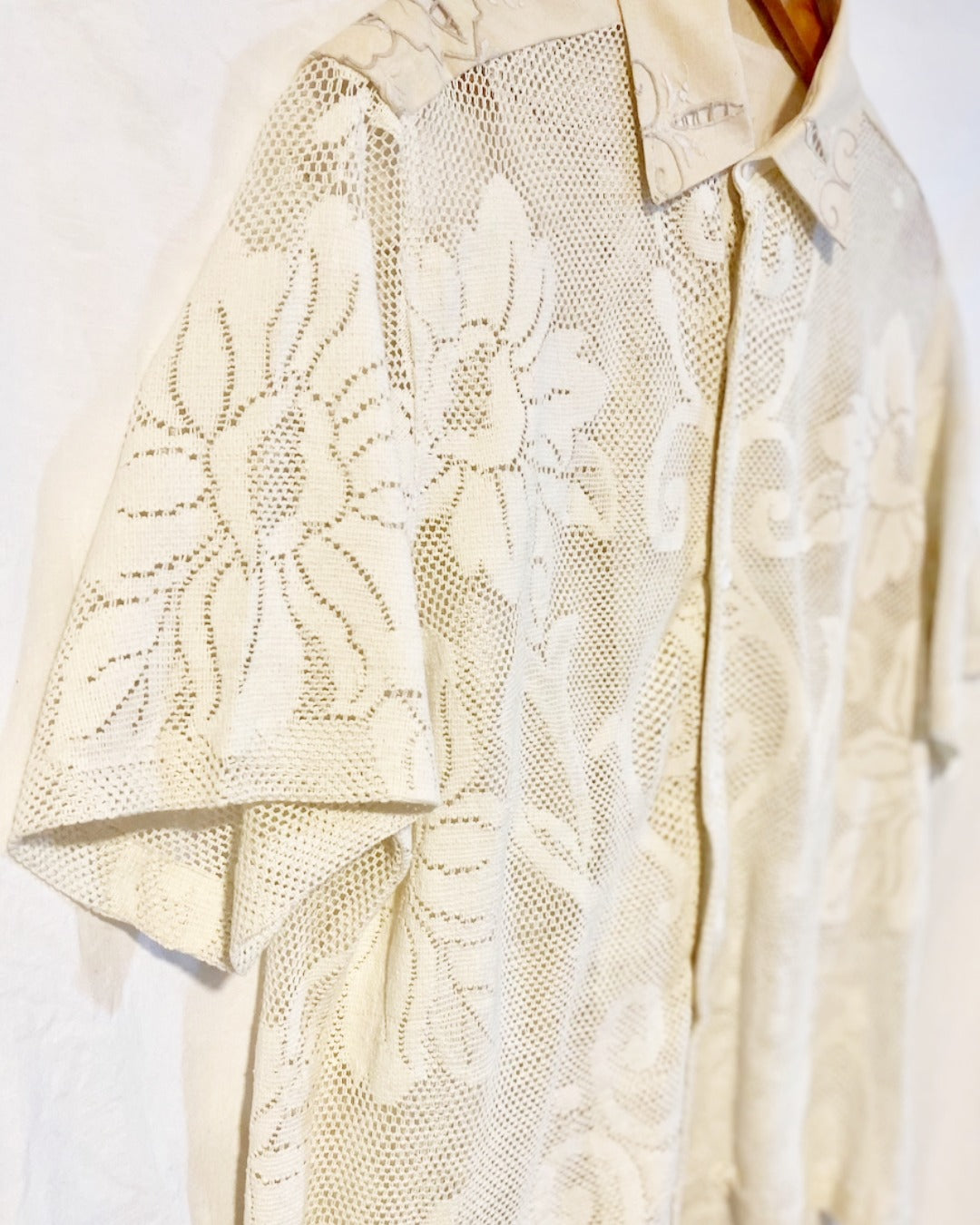 The Ivory shirt is an individually handcrafted unisex piece. It is made from a vintage machine knitted (stretch) cotton lace table cloth and is teamed with a linen embroidered supper cloth for the collar and back yoke
