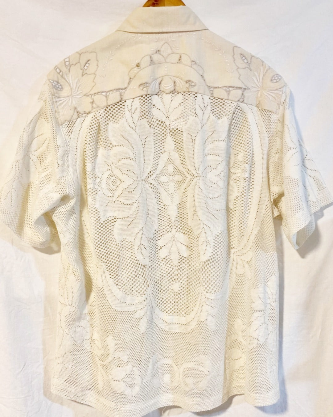 The Ivory shirt is an individually handcrafted unisex piece. It is made from a vintage machine knitted (stretch) cotton lace table cloth and is teamed with a linen embroidered supper cloth for the collar and back yoke
